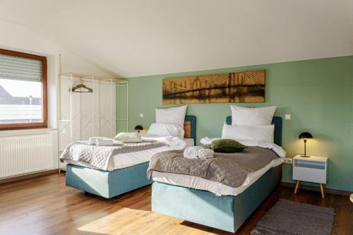 two beds in a room with green walls at Team Haus -6Zimmer 12Betten Parkplätze Grillen Terrasse Balkone schnell nach Augsburg und München in Mering