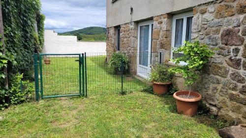 a gate to a building with plants in a yard at Gîte familial avec jardin privatif - près de Rocamadour et Padirac in Saint-Michel-de-Bannières