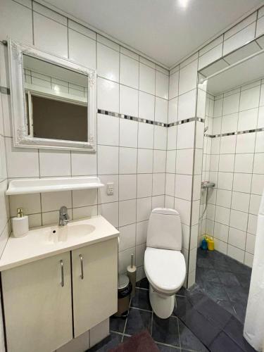 a white bathroom with a toilet and a sink at Hyggelig, lys og centralt lejlighed in Esbjerg