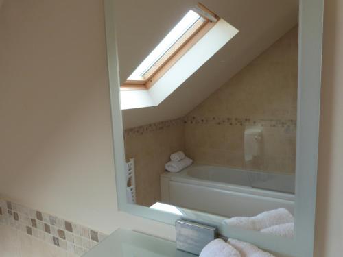uma casa de banho com uma banheira e uma janela em Groesfaen Bach em Caerwys