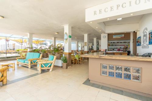 a restaurant with a counter and chairs and tables at Hotel La Fragata Coveñas in Coveñas
