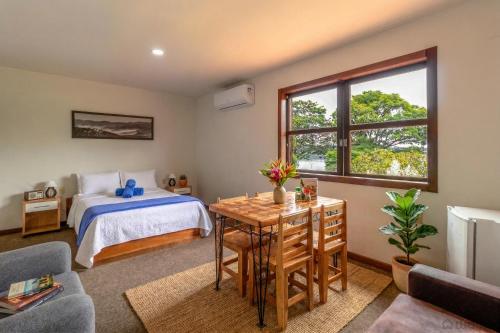 a bedroom with a bed and a desk and a table at Wafeh Pampulha Suítes in Belo Horizonte