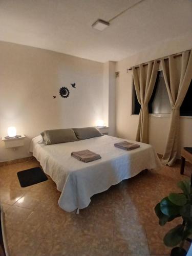 a bedroom with a large white bed with curtains at Casa Serena in Munro