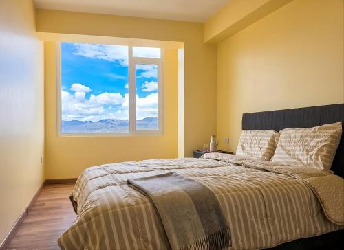 a bedroom with a large bed with a large window at Cusco Nest in Cusco