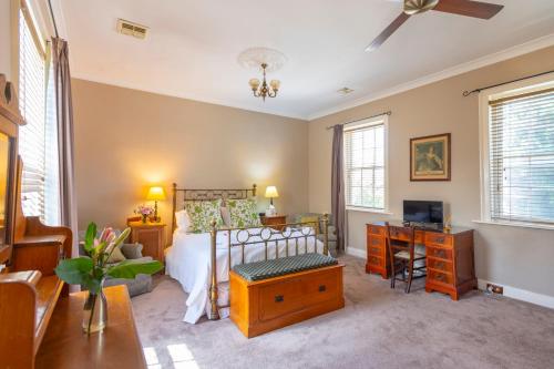 a bedroom with a bed and a desk with a television at The Globe Inn in Yass