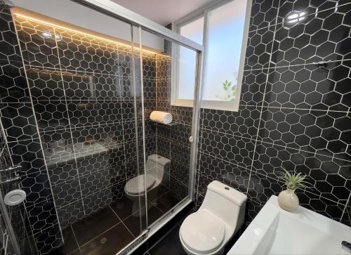 a bathroom with a toilet and a glass shower at Cusco Nest in Cusco