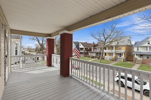a porch of a home with an american flag at Modern Niagara Loft with Private Sunset Balcony Duplex in Niagara Falls