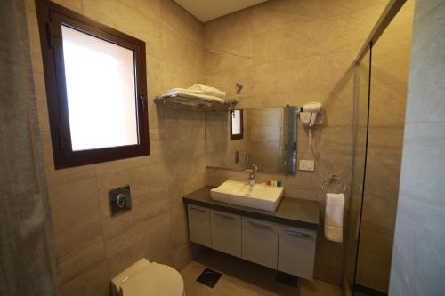 a bathroom with a sink and a toilet and a window at Asamina Boutique Hotel in Soûr