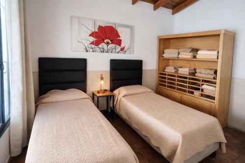 a room with two beds and a shelf with towels at JACARANDA - Alojamiento vacacional in Godoy Cruz