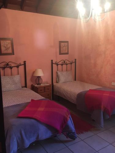 a bedroom with two beds and a chandelier at Casa Gusber 2 in La Rosa