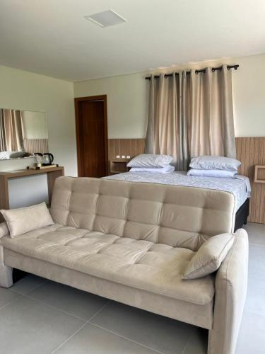 a large bed with a couch in a room at Castel Luz in Angelina