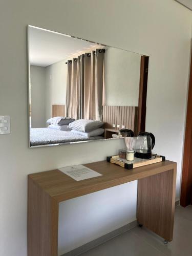 a mirror above a desk with a bed in a bedroom at Castel Luz in Angelina