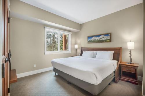 a bedroom with a large bed and a window at Star Suite -Luxurious condo with 3 fireplaces, and open Pool! in Canmore