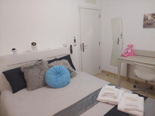 a bedroom with a bed with a blue pillow and a desk at Ketchs House in Ponte de Sor