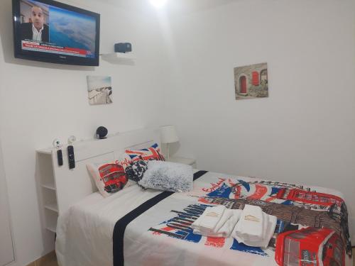 a bedroom with a bed with a tv on the wall at Ketchs House in Ponte de Sor
