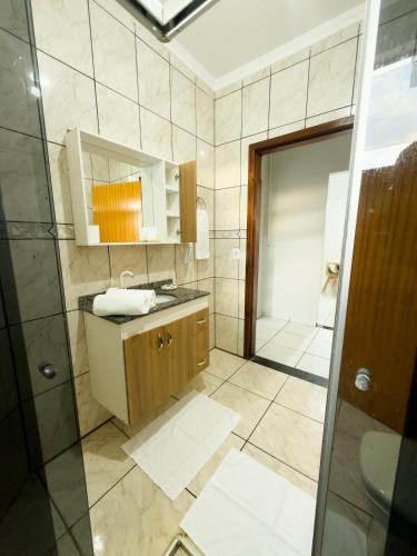 a bathroom with a sink and a shower at Apartamento Super Conforto in Naviraí