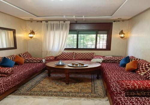 a living room with two red couches and a table at Sidi Rahal Playa beach in Casablanca