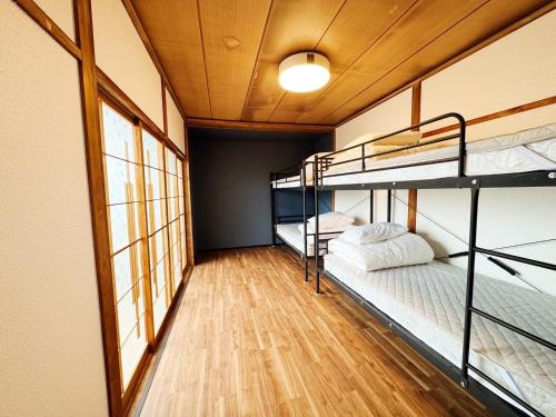 a room with three bunk beds in a room at Goryokaku rental house SAKURA in Hakodate