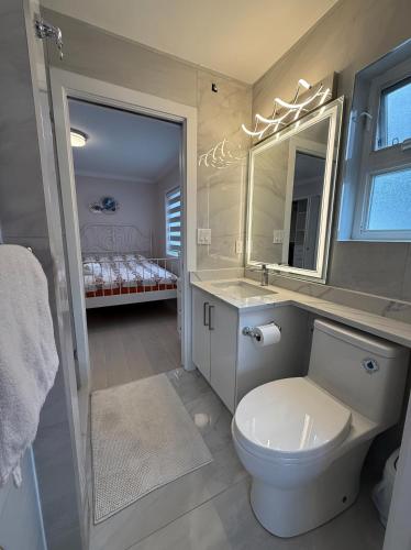 a bathroom with a toilet and a sink and a bed at Private Suite in a Friendly Shared Home in Vancouver