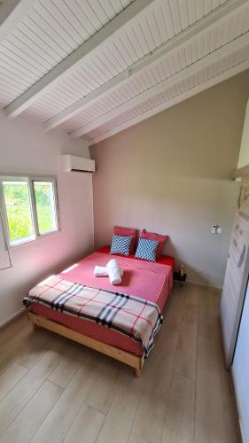 a bedroom with a red bed in a room at Canopée Créole in Petit-Canal