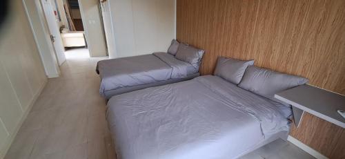 a bed with pillows and a table in a room at Elim Hotel in Neiafu