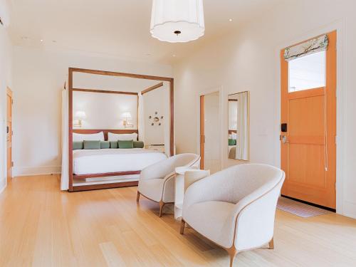 a bedroom with a bed and two chairs and a mirror at Okaeri in Calistoga