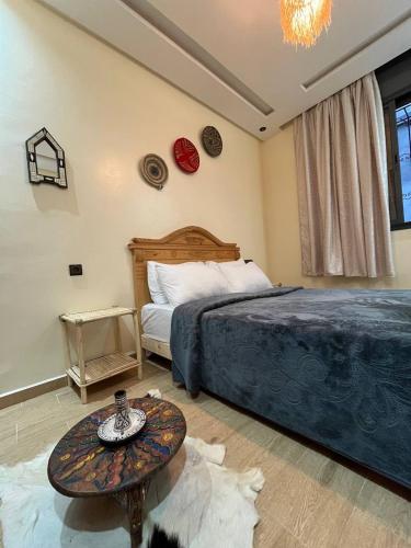 a bedroom with a bed and a table in it at Breeze surf lodge in Tamraght Ouzdar