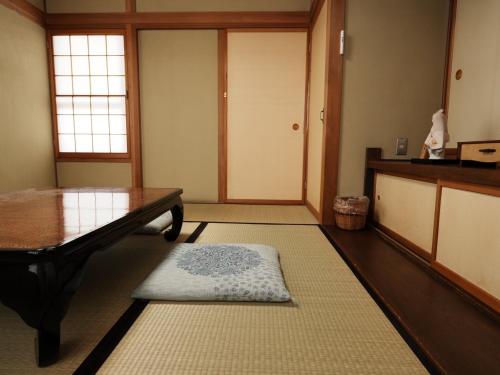 a room with a table and a rug on the floor at ゲストハウス豆まめ - Guesthouse Mamemame in Matsumoto