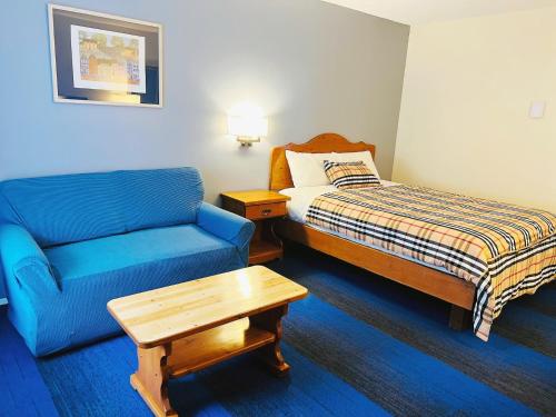 a hotel room with a bed and a couch and a table at Chase Country Inn in Chase