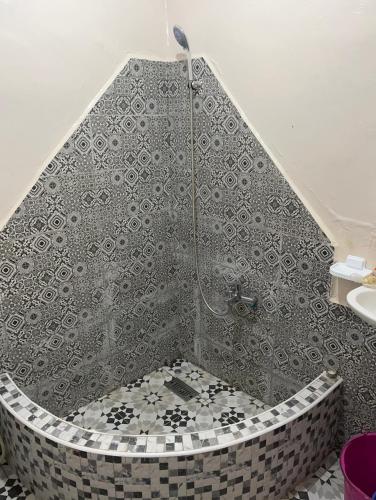 a bathroom with a shower with a tiled floor at Riad Dar khadija in Taroudant