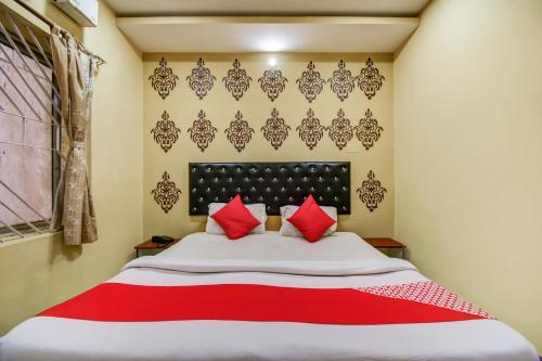 a bedroom with a large bed with red pillows at Super Hotel O Priyal Amrit Sagar in Rourkela