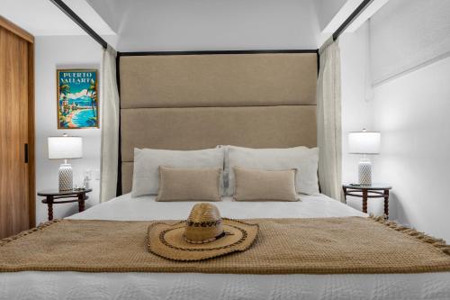 a bedroom with a bed with a hat on it at Casa Corazon at Harbor 171 North Tower in Puerto Vallarta