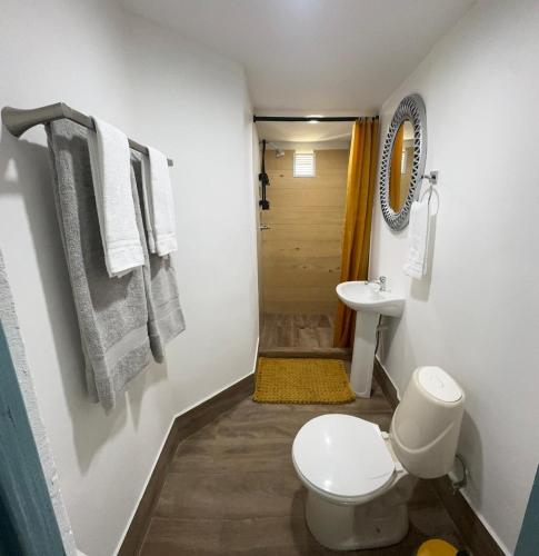 a bathroom with a toilet and a sink at Arubaapartamentos in Oranjestad
