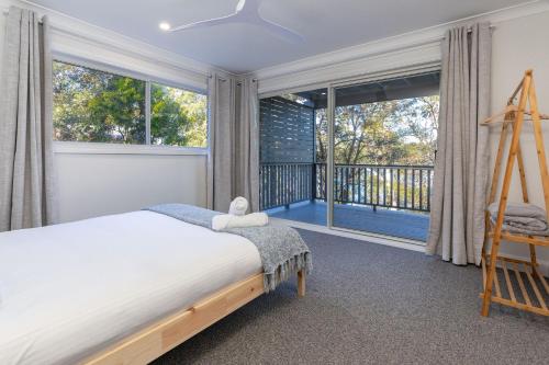 a bedroom with a bed and a large window at Billie's on Smiths in Smiths Lake