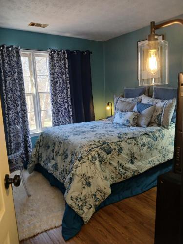 a bedroom with a bed with blue walls and a window at Southern Charmer in Stone Mountain