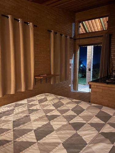 a bedroom with a large bed and a large window at Refúgio Rodreipe II in São Bento do Sapucaí