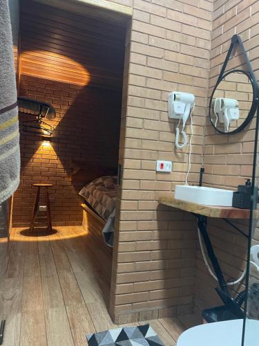 a bathroom with a sink in a brick wall at Refúgio Rodreipe II in São Bento do Sapucaí