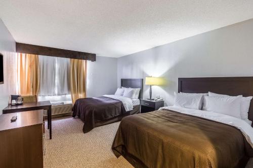a hotel room with two beds and a window at Clarion Inn near McAllen Airport in McAllen