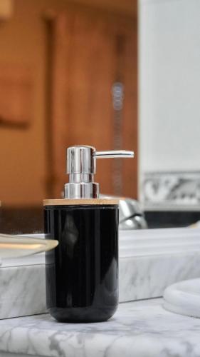 a black soap dispenser sitting on top of a counter at Al ladito de Sevilla in Bormujos