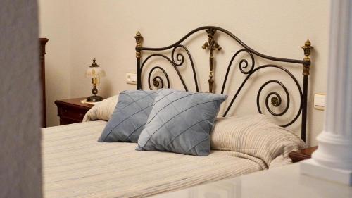 a bedroom with a bed with a metal headboard at Al ladito de Sevilla in Bormujos