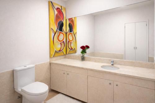 a bathroom with a toilet and a sink and a mirror at Free Wave Rooms in Maia
