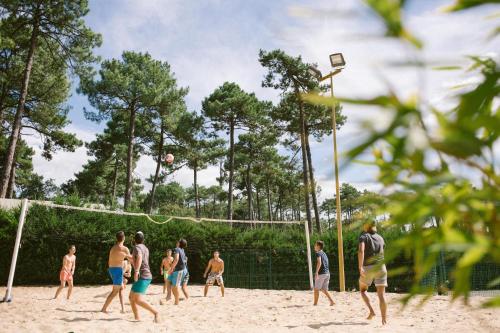 a group of people playing volleyball on a beach at Naturéo in Seignosse