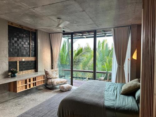 a bedroom with a bed and a large window at Chum Home in Thanh Ðông (1)
