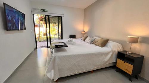 a bedroom with a large white bed and a table at Piccolo Posto in Neuquén