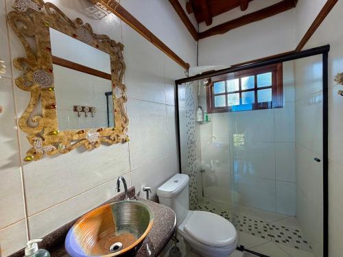 a bathroom with a sink and a toilet and a mirror at Mirantes Paraibuna - Casa Vermelha in Paraibuna