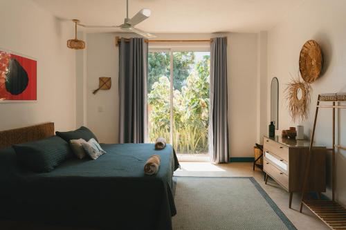 a living room with a bed and a large window at Maralagua in Puerto Escondido