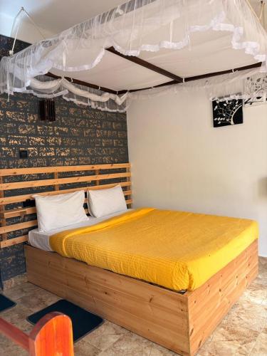a bedroom with a wooden bed with a canopy at Mountain Shack Homestay in Ella