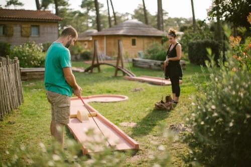 a man and a woman standing in a yard with a play equipment at Naturéo in Seignosse