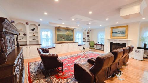a living room with leather chairs and a fireplace at Snow Circle Retreat in Bourne