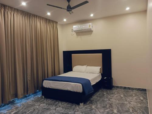 a bedroom with a bed and a ceiling fan at hariholidaysvilla in Chennai
